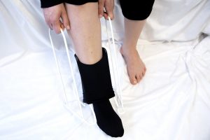 Kuvassa estohoidossa käytettävä apuväline, jonka avulla tukisukan laittaminen kipeäänkin jalkaan on mahdollista