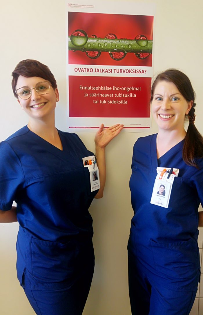Sairaanhoitajat Laura Salmi ja Tiia Helen alaraajaturvotuksen estohoidon julisteen kanssa.