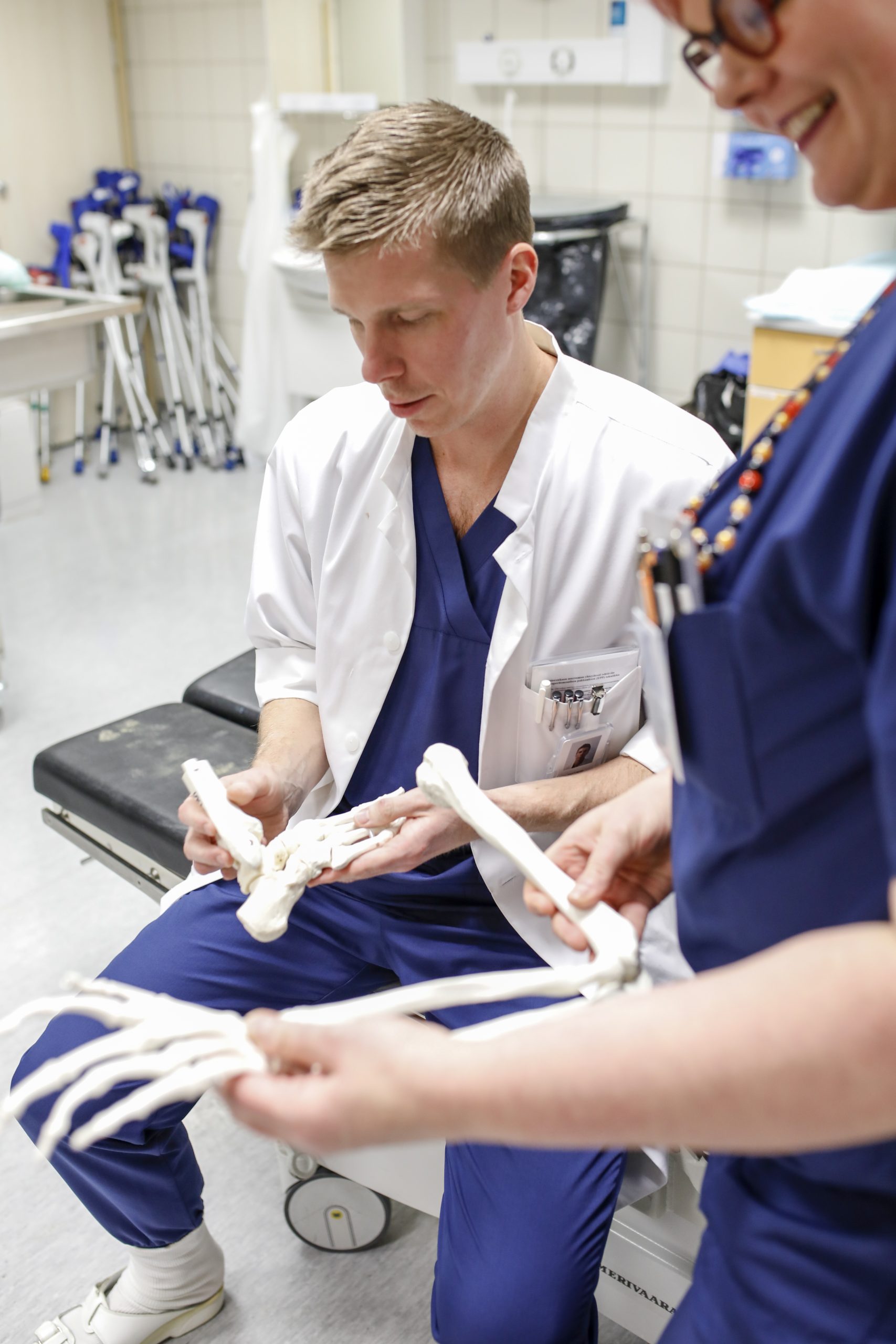 Ortopedian ylilääkäri Jussi Laurila pitää käsissään luumallia, jolla potilaalle voidaan havainnollistaa jalan rakennetta.
